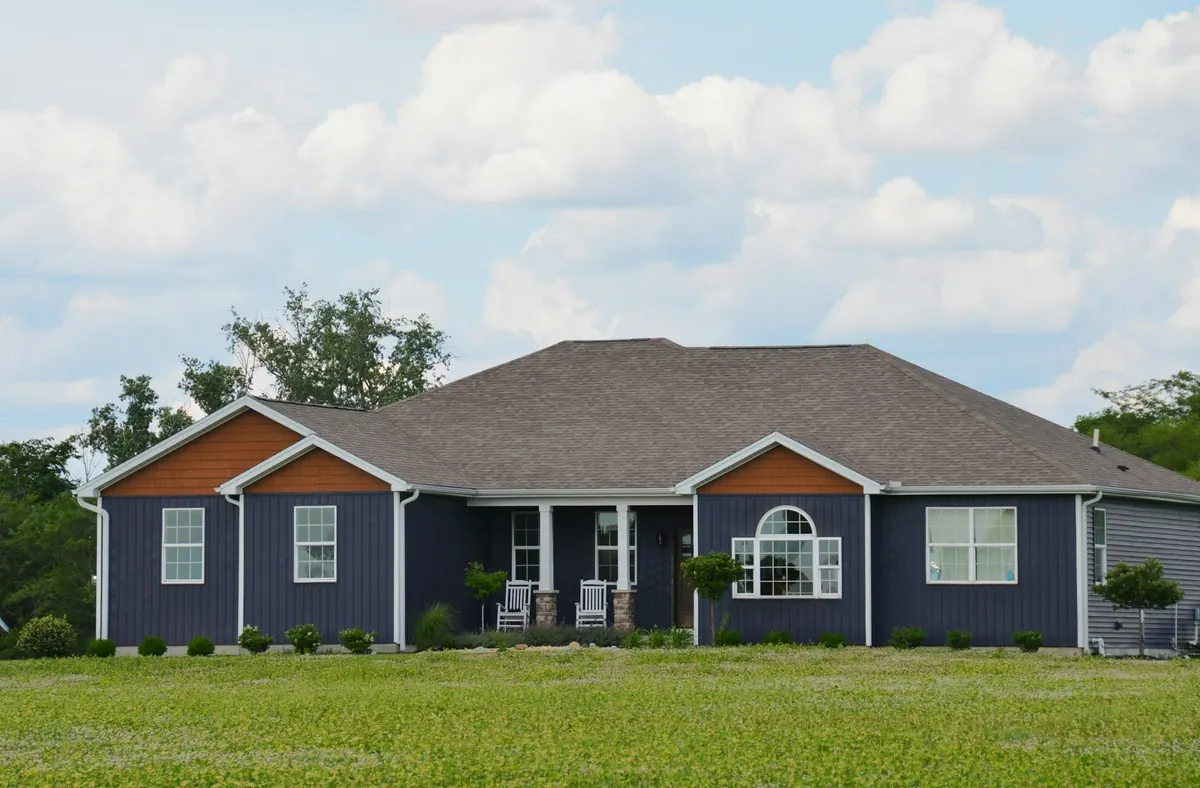 A house with navy board-and-batten siding, crisp white trim and a covered porch