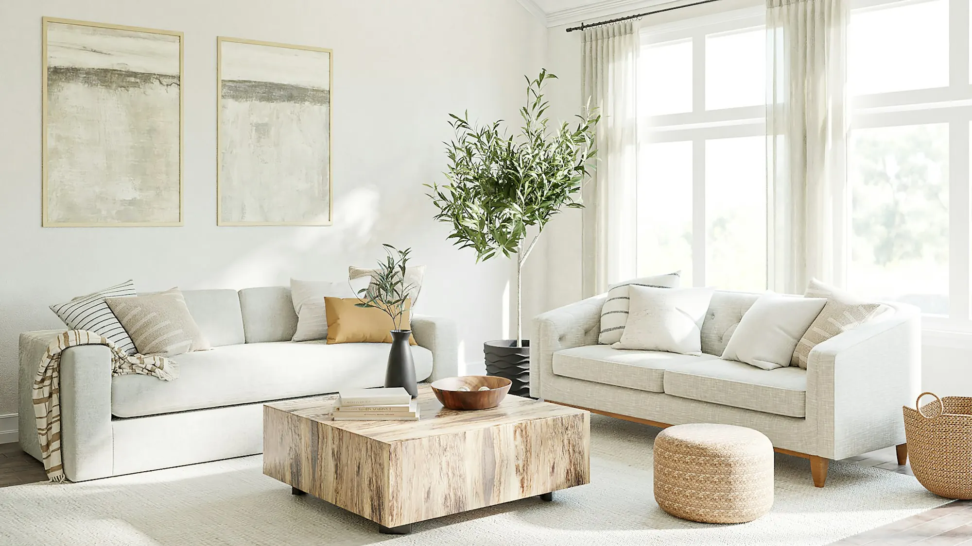 A bright living room with light linen sofas, a wooden coffee table, an olive tree and tall sheer-curtained windows