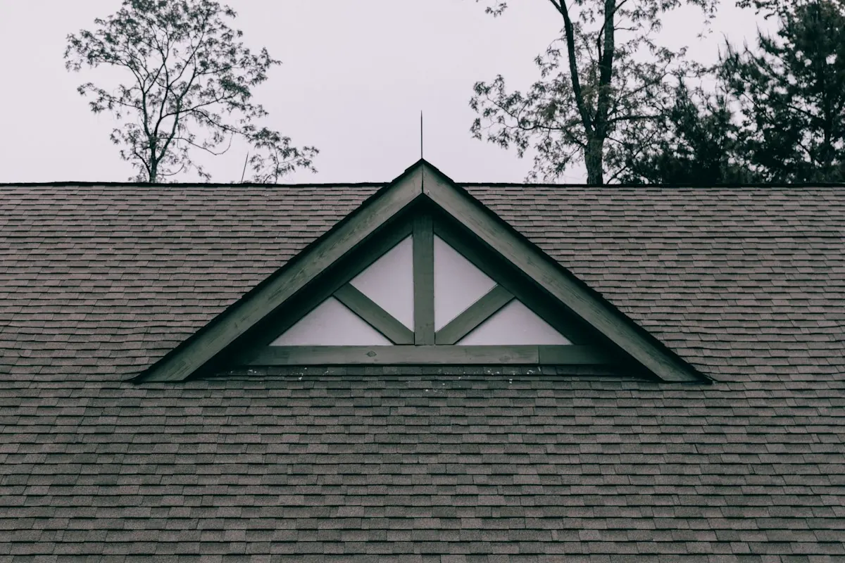 A newly reflashed dormer gable on a shingle roof